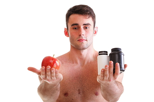 natural apple vitamin or pill drag tablet Man isolated offering pill in one and pills in bottle - in another hand. Copy space boxes with supplements