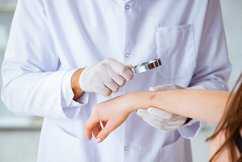 Doctor examining the skin of female patient