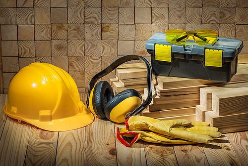 construction tools helmet gloves goggles earphones toolbox on wooden background