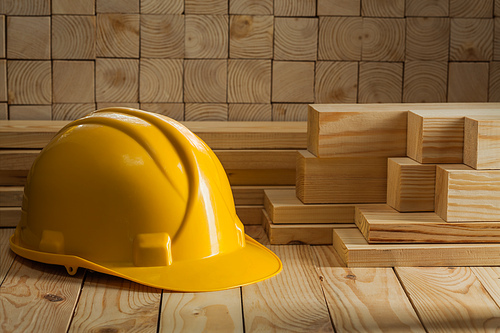 construction yellow helmet on wooden background