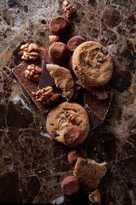 chocolate chip cookies with chocolate candies in the dark marble background.