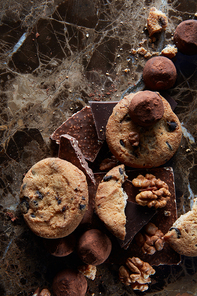 Fresh chocolate chip cookies with chocolate candies in the dark marble background.