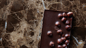 chocolate bar with nuts on a dark marble table