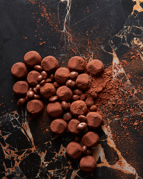 Luxury chocolate truffles on a black marble background.