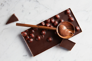 wooden spoon with caramel on a chocolate bar isolated on white