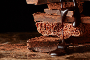 chocolate syrup dripping on stack dark chocolate