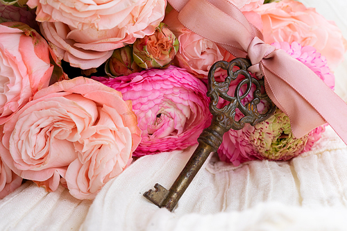 antique rusty skeleton key with pink ranunculus bouquet