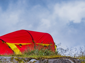 Camping. Red yellow tent on nature in summer. Holidays and travel.