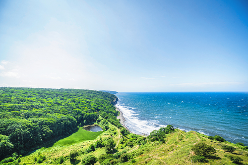 Ocean view over a valley by the sea with green forest and meadows