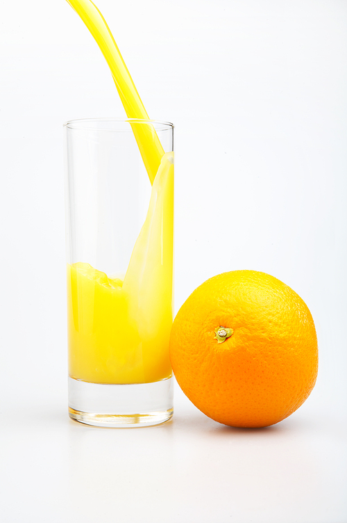 Glass of juice and orange on a white background