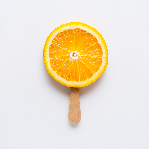 Creative concept photo of orange slice arranged as ice cream popsicle on grey background.