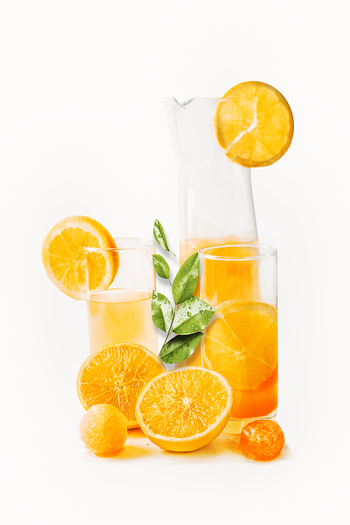 Orange juice in glasses and jug with slices and green leaves at white background. Healthy drinks. Summer beverages. Refreshing. Vitamin C