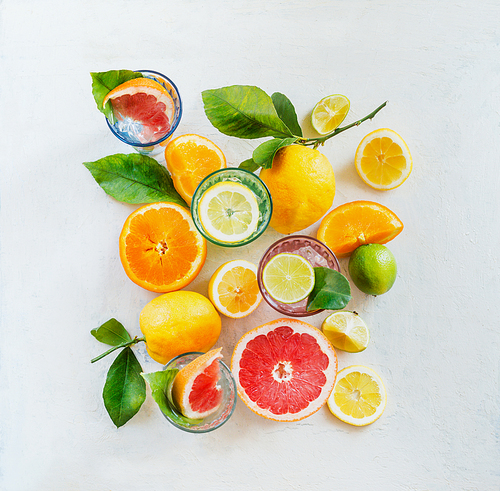 Group composition of various organic citrus fruits with green leaves on white background, top view. Healthy food.  Ingredients. Vitamin. Halves and slices. Layout