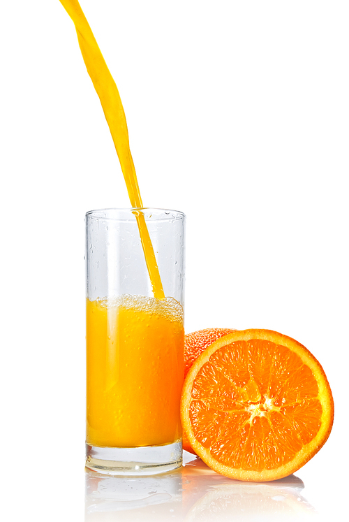 orange juice poring into glass isolated on white