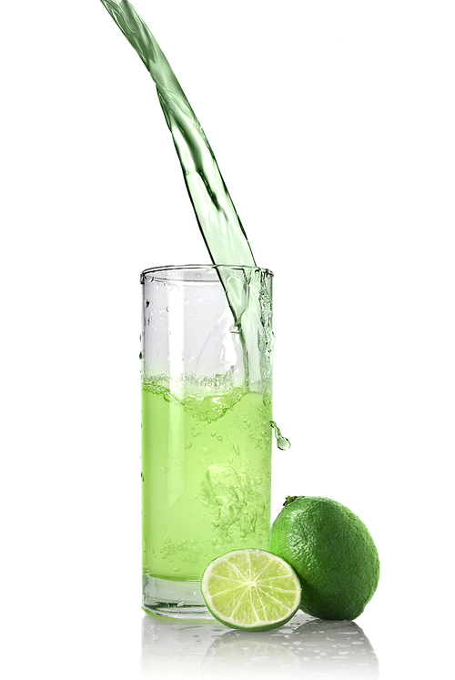 green juice with lime pouring into glass isolated on white