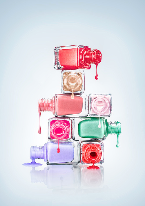 Nail polish dripping from stacked bottles.
