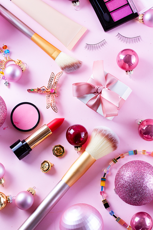 Festive make up products on pink background, top view