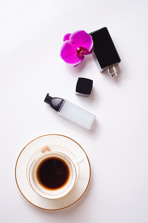 cup of coffee with perfume and care essence around white background. life style flat lay