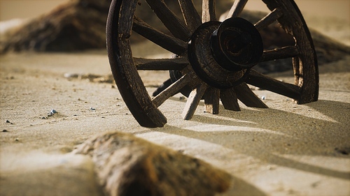 Large wooden wheel in the sand