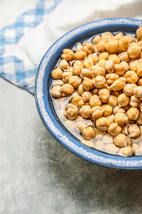 Chick peas , hummus in blue rustic bowl with water