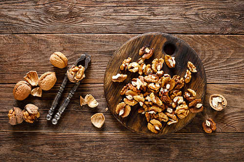 Walnuts. Kernels and whole nuts on wooden rustic table, top view