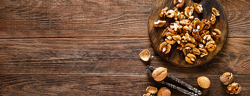 Walnuts. Kernels and whole nuts on wooden rustic table, banner, top view
