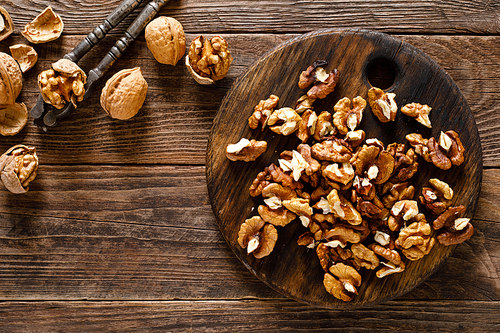 Walnuts. Kernels and whole nuts on wooden rustic table, top view