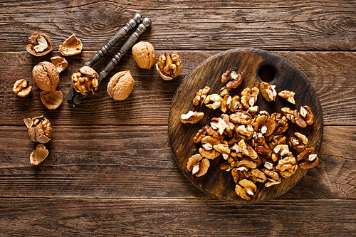 Walnuts. Kernels and whole nuts on wooden rustic table, top view