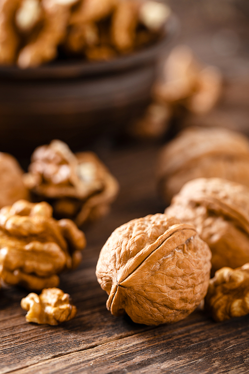 Walnuts. Kernels and whole nuts on wooden rustic table