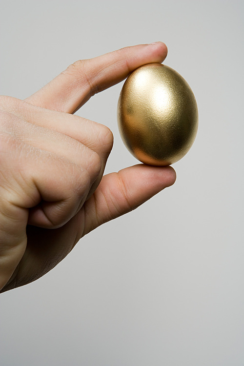 Hand holding a golden egg