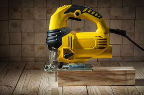 construction tools electric corded jigsaw on wooden background
