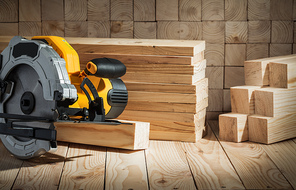 electric power tool corded circular hand saw on wooden background