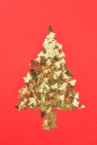 New Year creative decorative tree handmade frome shiny small spruces on a red background with place for text. Greeting holiday card.