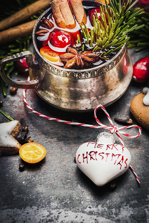 Mug of mulled wine with spices , cookies and  Christmas decoration