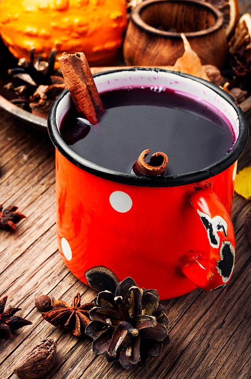 Mulled wine hot drink and spices in rustic mugs on rustic background
