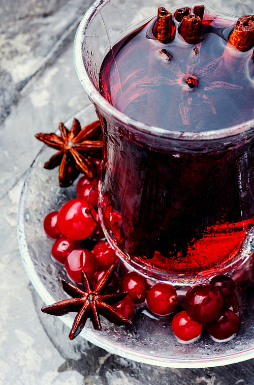 Winter hot tea with berries and spices in glass cup.Mulled wine with fresh cranberry