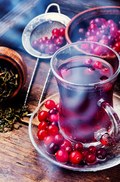 Winter hot tea with berries and spices in glass cup
