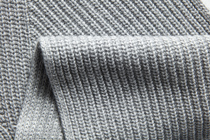 Closeup macro texture of knitted cotton waffle fabric, clothing background with wrinkles and folds