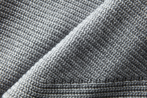 A full page close up of gray knitted jumper material texture