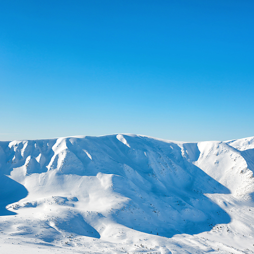 Range of white winter mountains peaks with snow