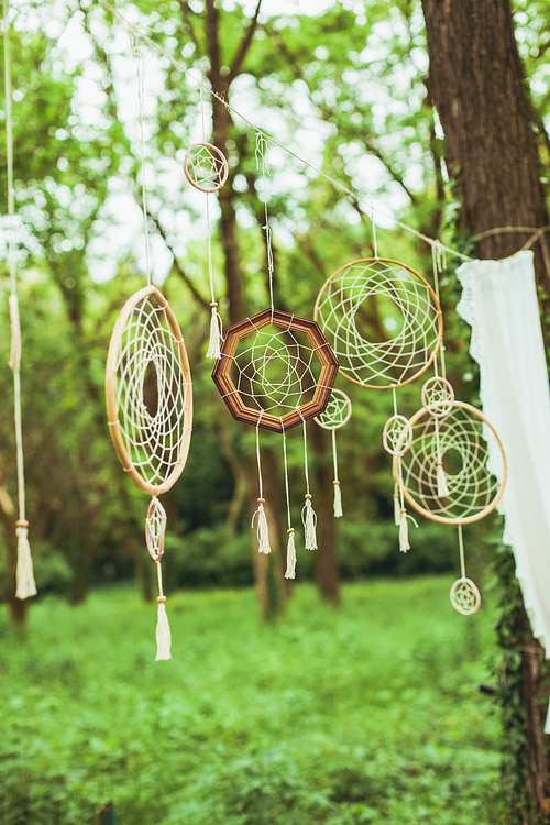 Decor with dream-catchers on a green forest background