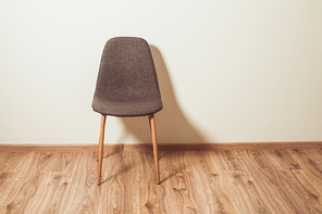 Chair stands near the wall in the empty room
