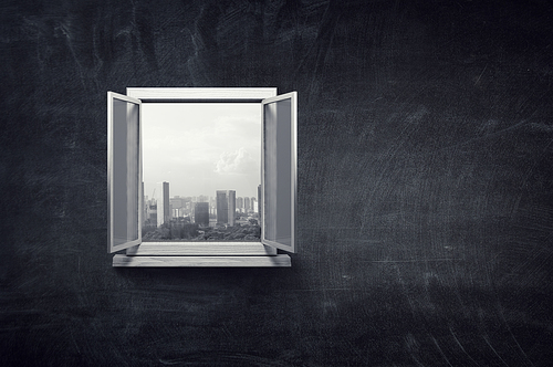 City view in window from inside of a room with black chalk board wall
