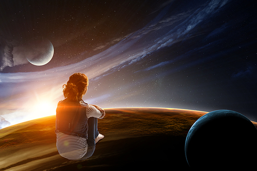 Back view of young woman in casual clothes sitting and hugging knees, space background