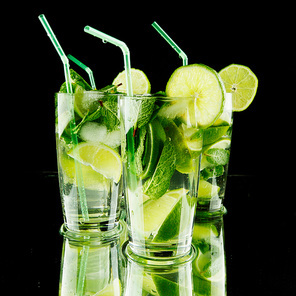 Mojito cocktails with lime and mint on black background