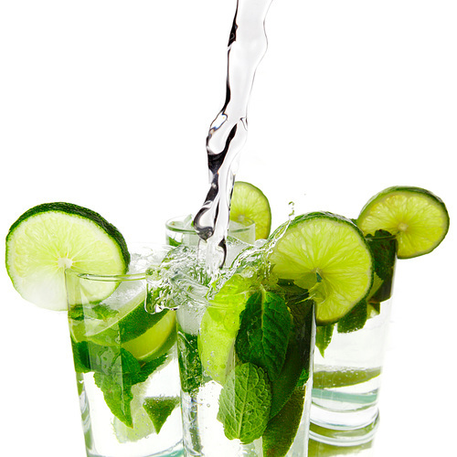 Making mojito cocktails with lime and mint isolated on white