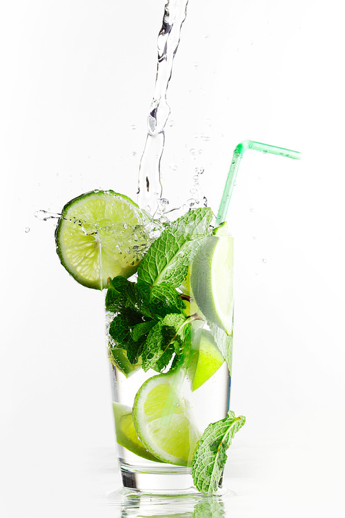 Making mojito cocktail with lime and mint isolated on white