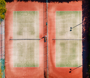 Aerial view of tennis court at sunset in summer. Top view from flying drone of green tennis courts. View from above of sport training field at sunny bright day. Background and concept. Sporting area