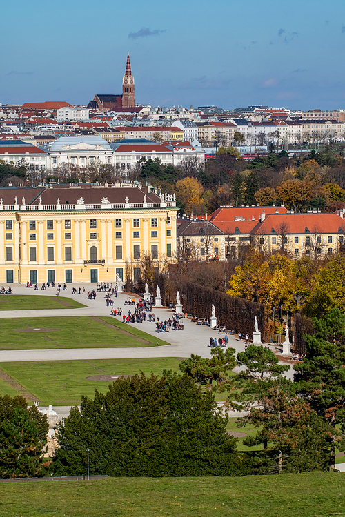 Verical cityscape with half of buildings Schonbrunn Palace in Vienna, Austria and roofs of other historical houses on a background of blue sky on an autumn day.