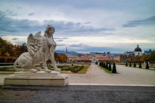 Historical landscape with marble sculpture of Woman Sphinx on a parapet of Schloss Belvedere Palace in Vienna, Austria on a background of grey cloudy sky on autumn day.